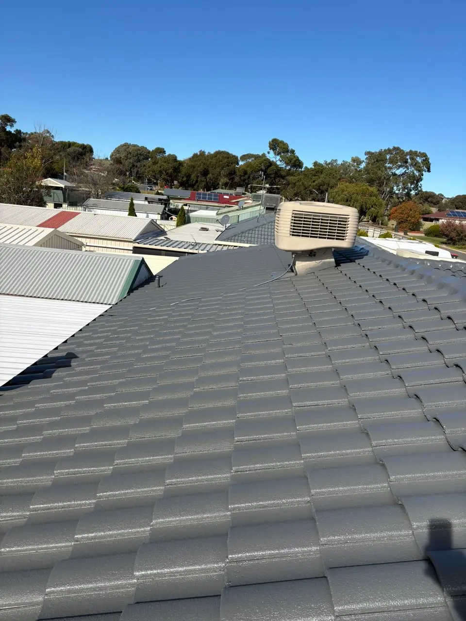 Freshly coated charcoal tile roof with evaporative cooler